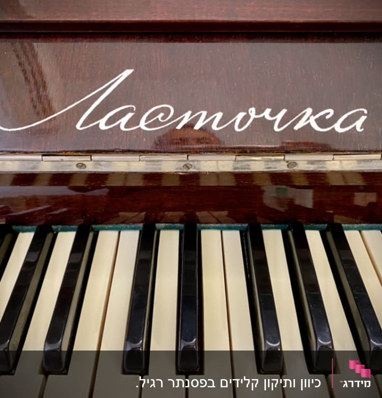 קלידים של פסנתר עם כיתוב על המכסה